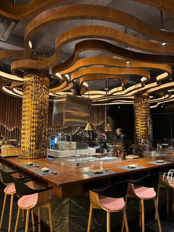 Interior restoran Hakata Tenjin Senopati dengan kisi-kisi kayu, meja makan, dan pencahayaan hangat